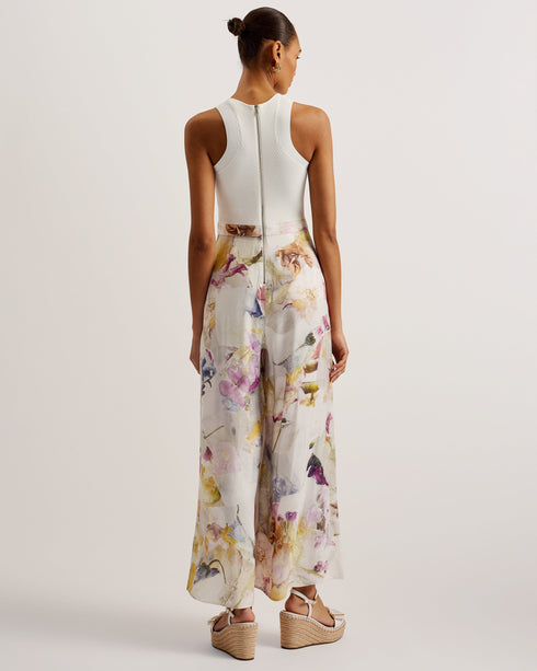 TIRSSO-Trousers-Switch up your special occasion fits with the TIRSSO jumpsuit. The top and trousers illusion brings effortless style, pairing a sleeveless bodice with wide leg bottoms for a flattering fit. The simple knitted top is elevated by a crossover neckline, and contrasts against the floral print of the trousers which adds a delicate pop of colour. Sleeveless jumpsuit Top and trousers illusion Pressed flower print Ribbed knit fitted bodice Crossover halter neck Wide leg trousers Exposed zip fastening